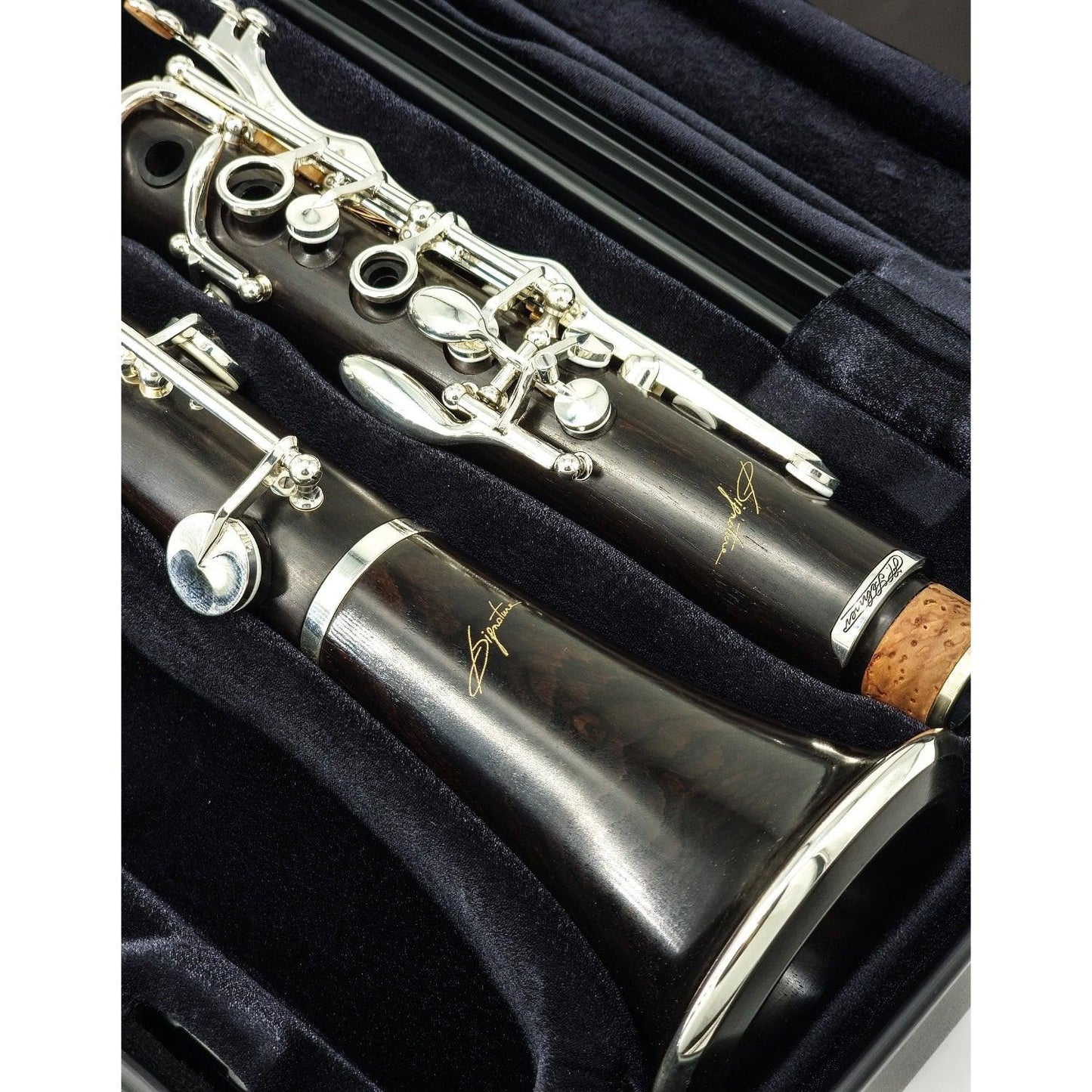 Selmer Signature Bb clarinet in case, showing wood grain on bell and upper joint medallion