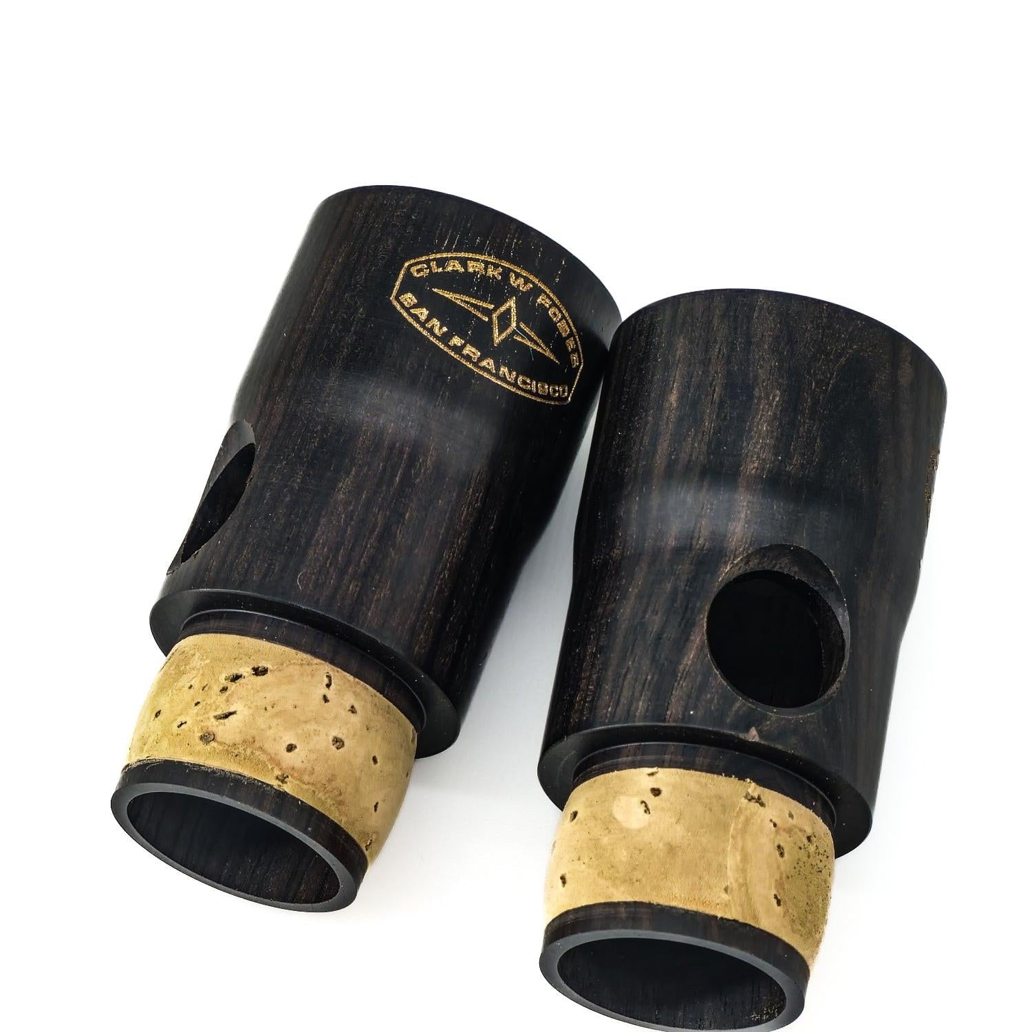 Two Fobes Eb clarinet extensions on a white background, one turned to showcase the logo, the other turned to the side to showcase the beveled vent hole in the side of the extension