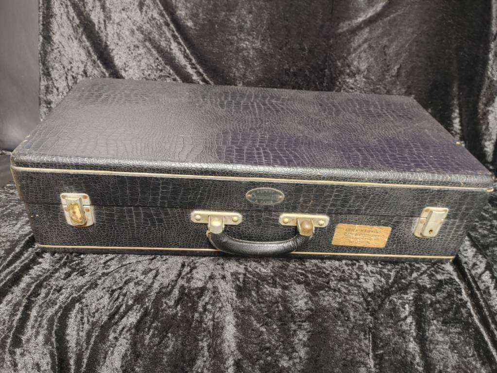 alligator-texture vintage bass clarinet case, closed, on black velvet