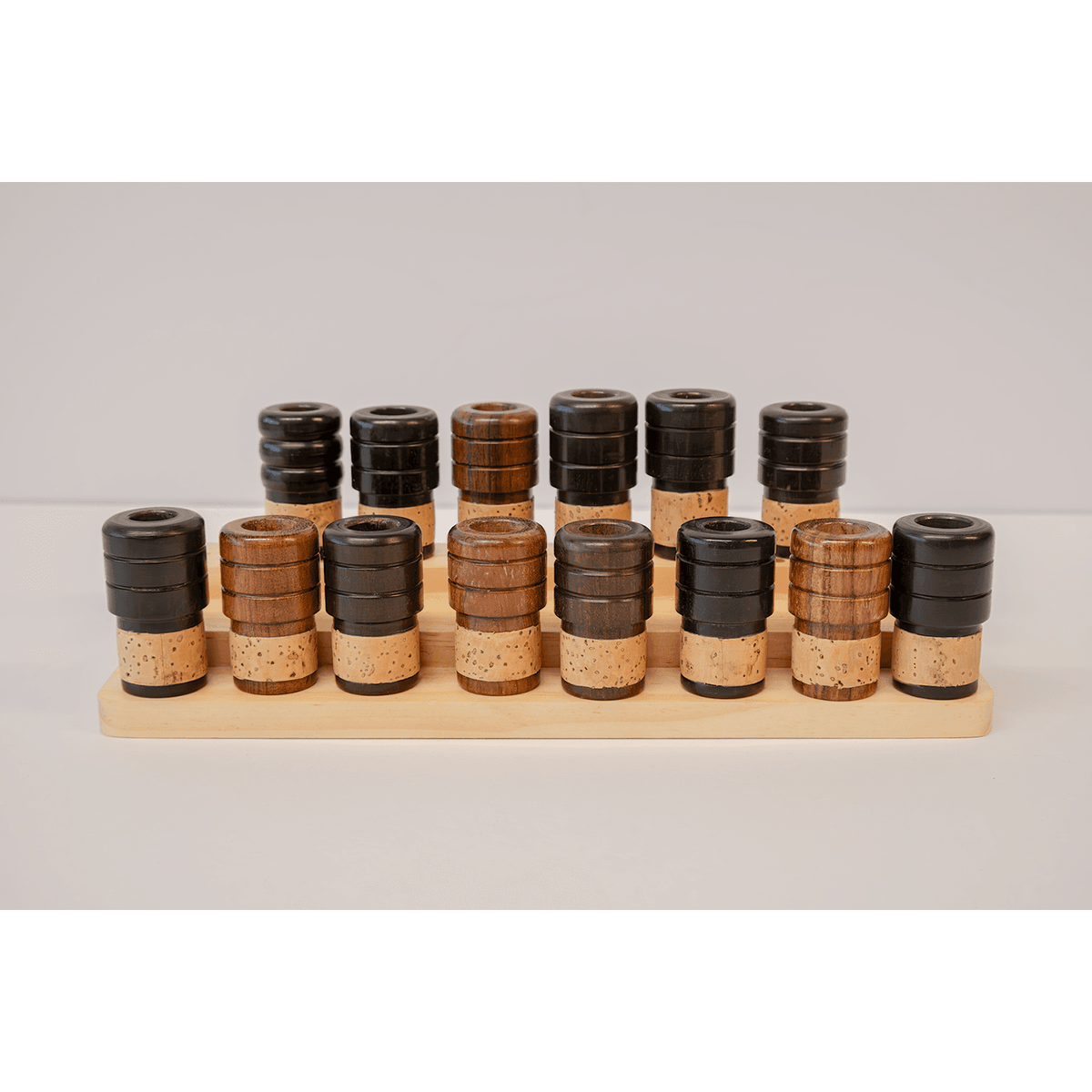 Various wooden alto saxophone end plugs arranged on a two tier peg stand - 7 upper row and 8 bottom row
