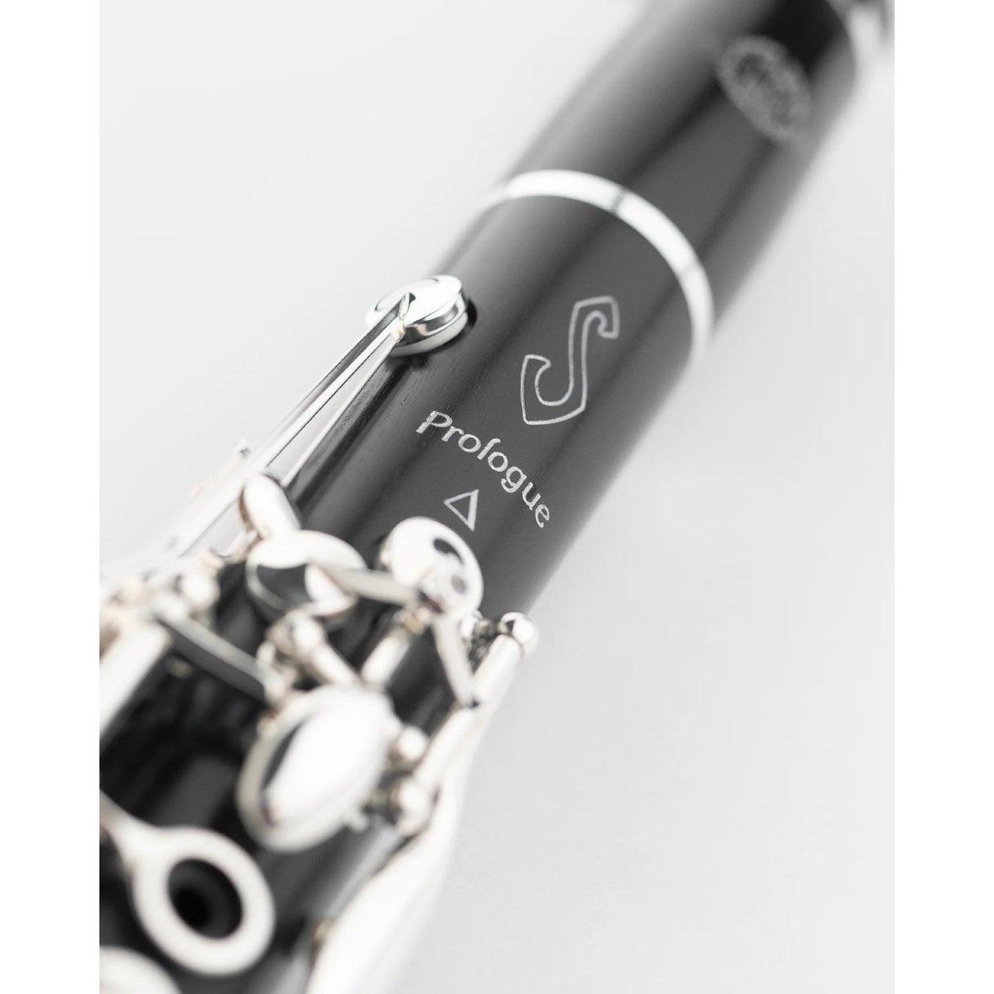 Close-up of a Selmer Prologue logo with silver keys on a light gray background