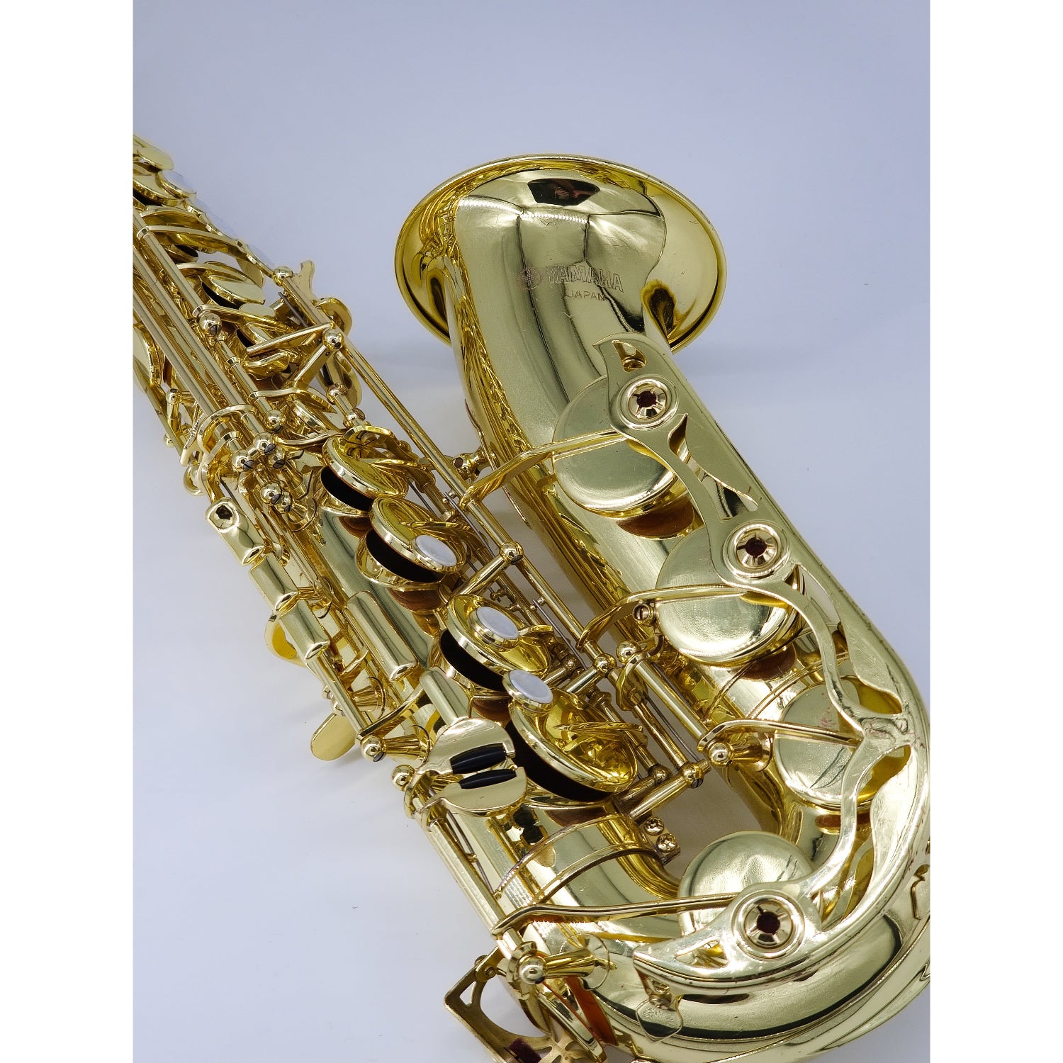 Gold saxophone on a light gray background, angled to the left, showing lower stack keys, featuring high F# key